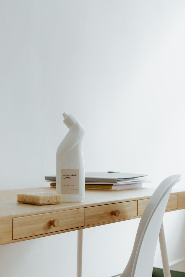 about-us-02 A tidy, well-arranged home office desk featuring a cleaning bottle and sponge, highlighting simplicity and practicality.